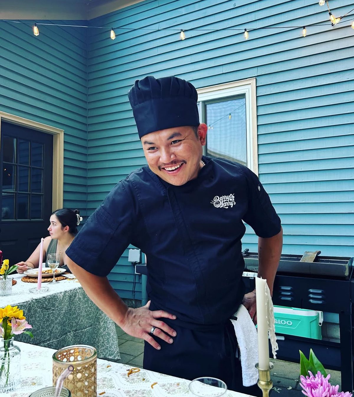 Barry Teng, aka Barry Larry, smiling in his chef hat and Barry Larry's branded coat