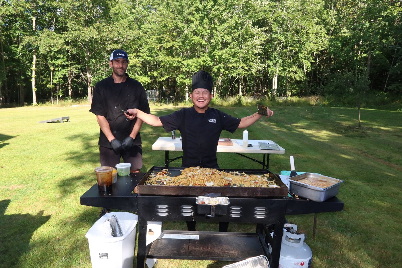 Barry Larry cooking hibachi-style on the griddle, tossing food with flames going