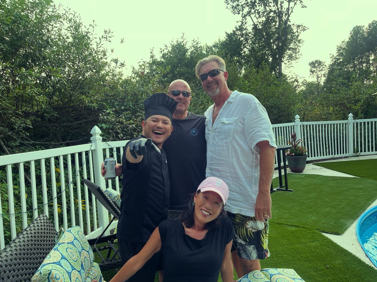 Barry Larry posing with happy guests at a poolside private event