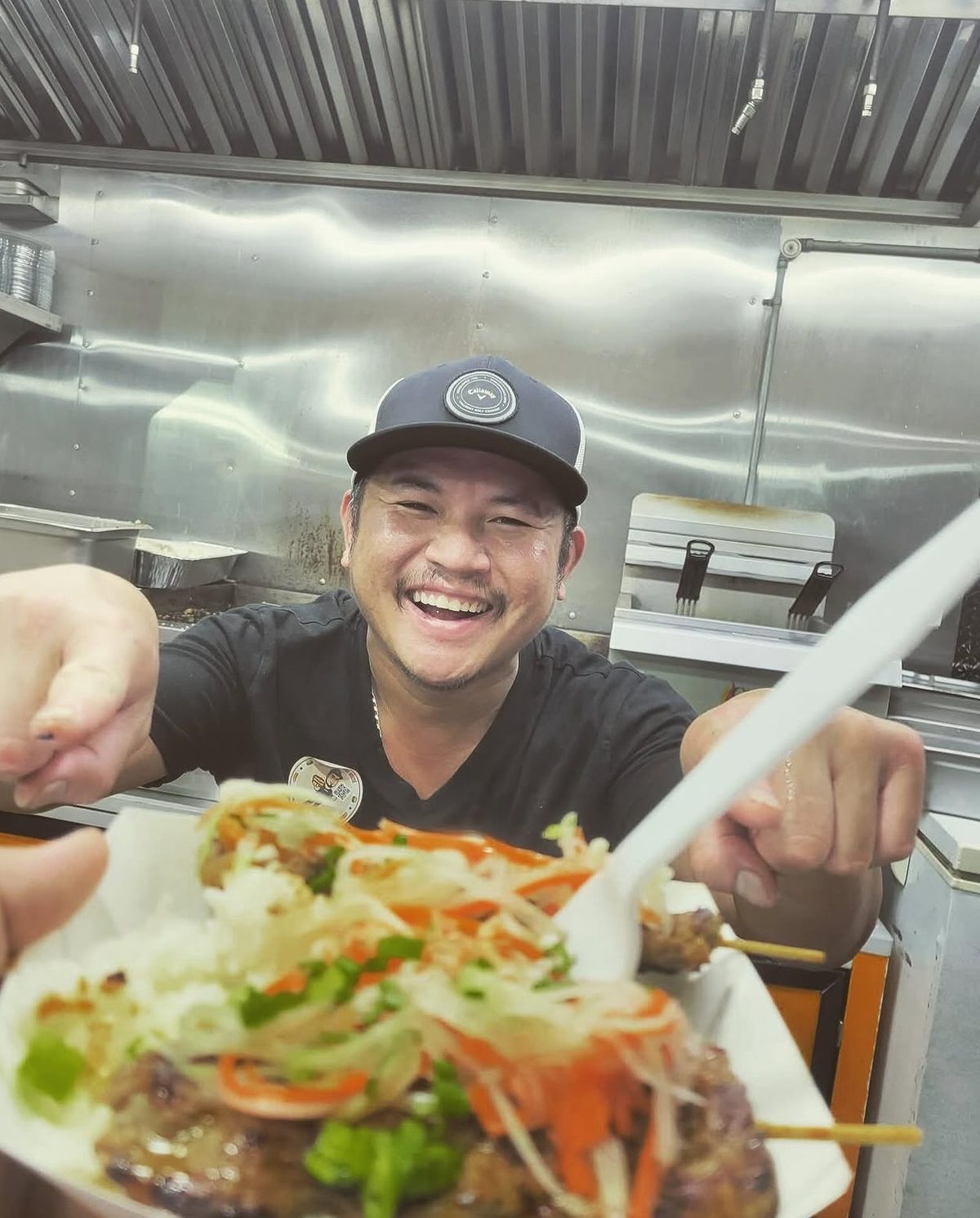 Barry Larry handing over a fresh skewer dish from the truck kitchen