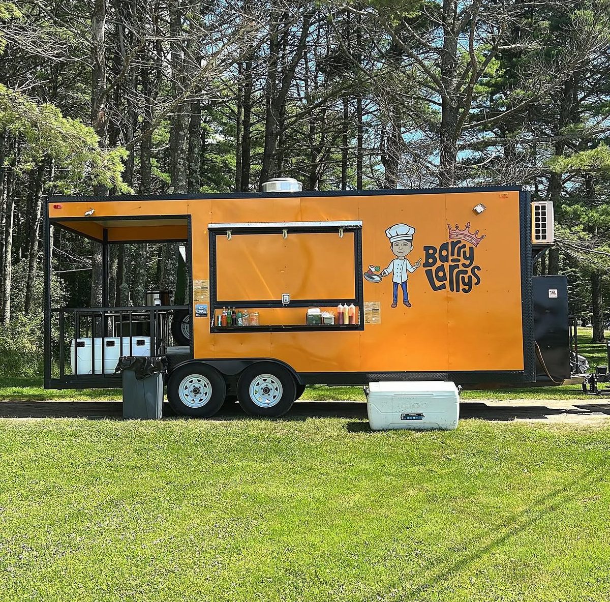 Barry Larry's orange food truck parked at an outdoor event